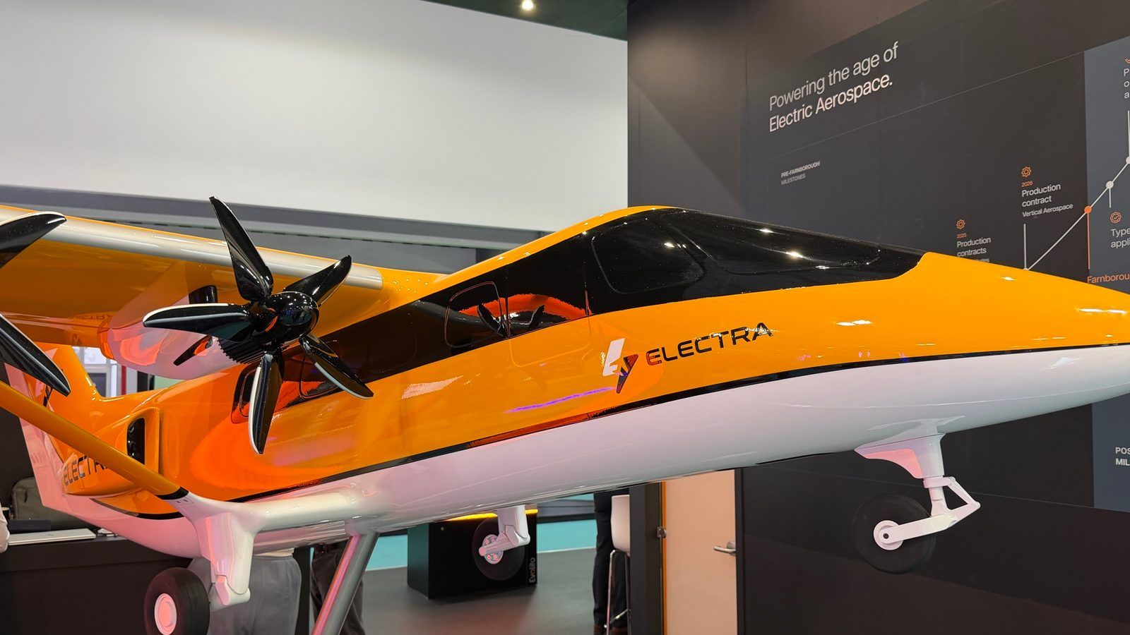 El Electra EL9 híbrido-eléctrico eSTOL en exhibición en el chalet de Electra durante el día de cierre del Farnborough International Airshow 2026, frente al muro de hitos de programa 'Powering the age of Electric Aerospace'.